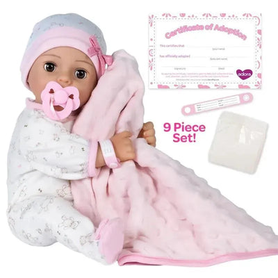 Adoption baby doll named Cherish, wearing pajamas, holding a pink blanket, with a pacifier and adoption certificate.