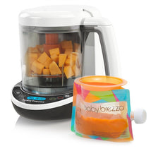 Baby Brezza Food Maker Complete, featuring a clear container with diced fruit, a digital display, and a colorful food pouch.