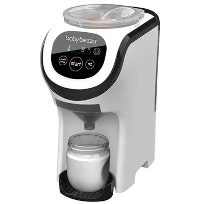 Baby Brezza Formula Pro Mini, a white automatic formula maker with a digital display, dispensing liquid into a glass jar.