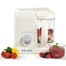 Beaba Babycook Solo 4 in 1 Baby Food Maker in white with fruits in the jar, fresh ingredients, and a glass of puree.
