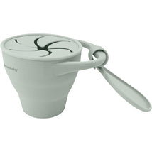 Foldable snack cup in seafoam color featuring a secure lid with slits for easy snacking and a handle for convenience.