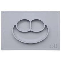 Silicone feeding mat in pewter color featuring a smiling face design with two compartments.