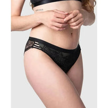 True Luxe Bikini in black featuring lace detailing and stylish side stripes, modeled by a woman.