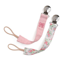 Two fabric pacifier clips in pink with a bow design and a floral pattern, featuring metal clips for attachment.