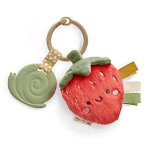 Plush strawberry-shaped toy with a teether, featuring a smiling face, colorful tags, and a green snail teether attached.