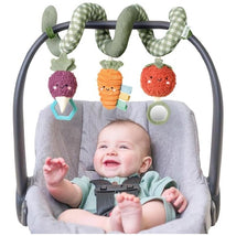 Spiral car seat activity toy featuring plush veggies: a purple radish, orange carrot, and red tomato with playful faces.