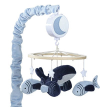 Musical mobile featuring plush whales and fish, suspended from a light wood frame with stars, ideal for nursery decor.