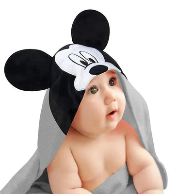 Hooded baby bath towel featuring a Mickey Mouse design, draped over a wide-eyed infant.