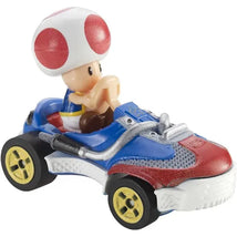 Toad figurine from Mario Kart sits in a blue and red racing car with gold wheels, featuring detailed designs and textures.