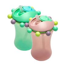 Two colorful sippy cups, one mint green and one pink, with decorative balls and straws for easy drinking.