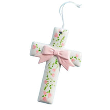 Ceramic cross ornament decorated with pink flowers and a pink bow, meant for display or gifting.