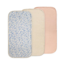 Three changing pad liners in a blue floral design, beige quilted, and soft pink, showcasing soft, protective surfaces for baby.