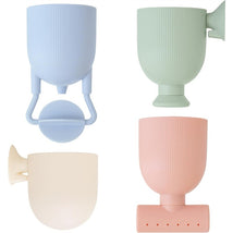 Four pastel silicone bath toys in blue, green, pink, and cream, designed for pouring and playing during bath time.