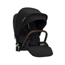 Nuna PIPA™ urbn Flex System Seat in Caviar color with a brown handle and adjustable hood, designed for infant safety.