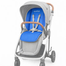 Primo Passi universal stroller liner in blue, featuring padded seating with adjustable straps in a gray stroller.