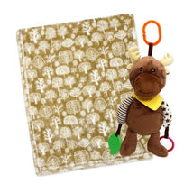 Plush tan moose activity toy with teething elements next to a patterned fleece blanket featuring tree designs.