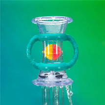 Clear double dip funnel with a colored ball inside, water flowing through, set against a vibrant green background.
