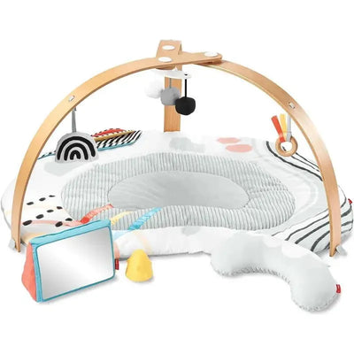 Montessori-inspired baby play gym with a colorful soft mat, hanging toys, and a mirror for infant play and exploration.