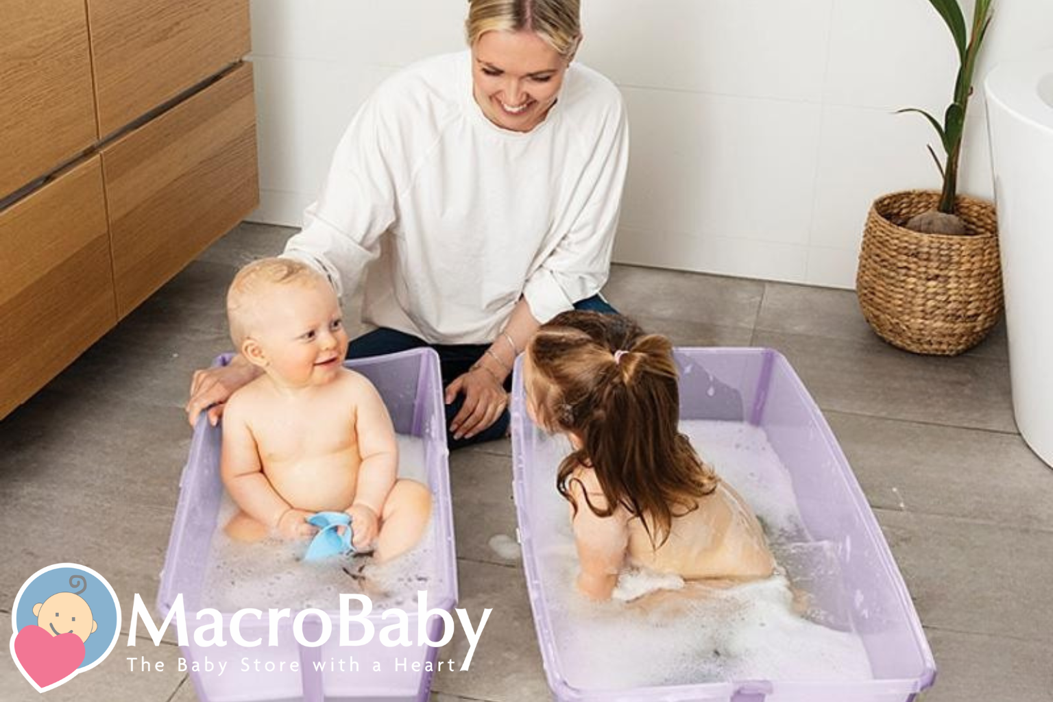 Mom bathing baby and toddler in purple tubs, bubbles, bathroom setting