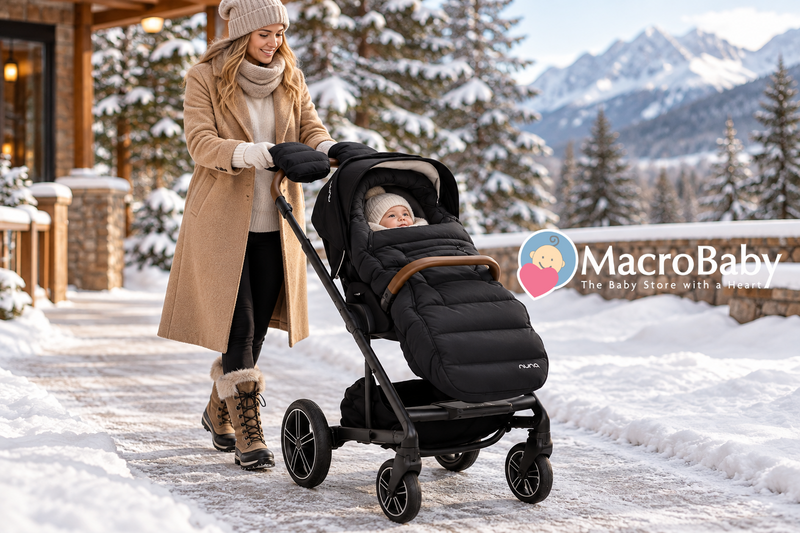 Mother pushing a black Nuna stroller with her baby on a snowy winter day.
