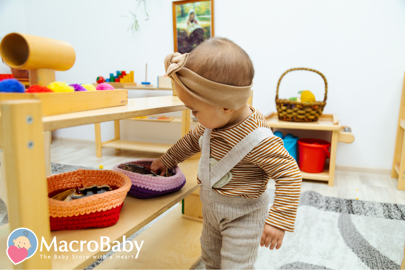 Toddler wearing a striped shirt and headband playing with toys on a wooden shelf