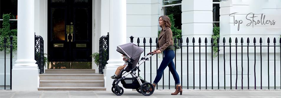 Woman pushing baby stroller on sidewalk near elegant home, top strollers for moms and babies