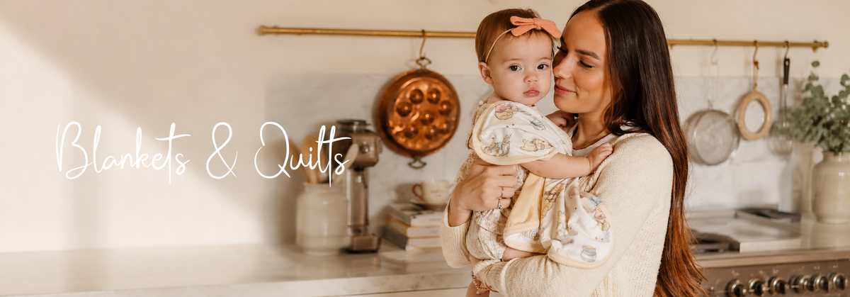 Mother holding baby wrapped in soft blanket, cozy kitchen setting with blankets & quilts text