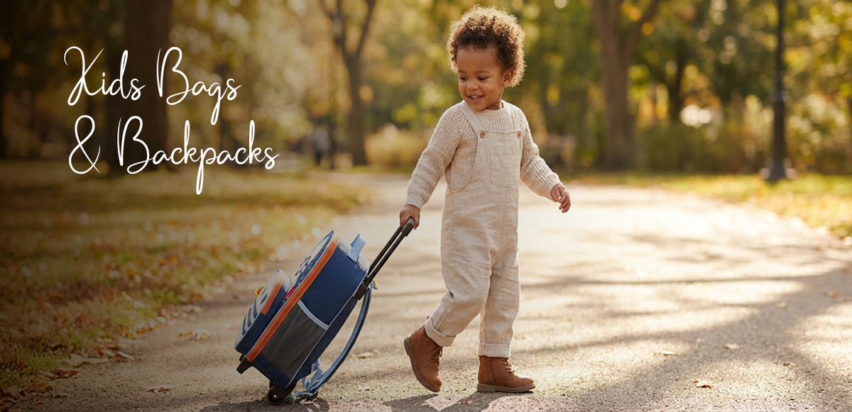 Toddler pulling blue rolling kids bag on park path, autumn leaves, cozy overalls