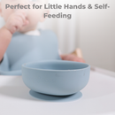 Light blue silicone baby bowl with suction base for self-feeding, perfect for little hands