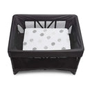 Breeze bassinet with a white, patterned mattress inside a black mesh frame, designed for infants.