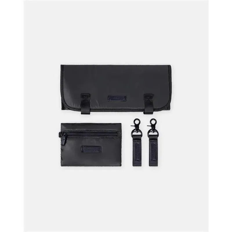 Diaper backpack accessories in black: a changing pad, a zippered pouch, and two detachable straps.