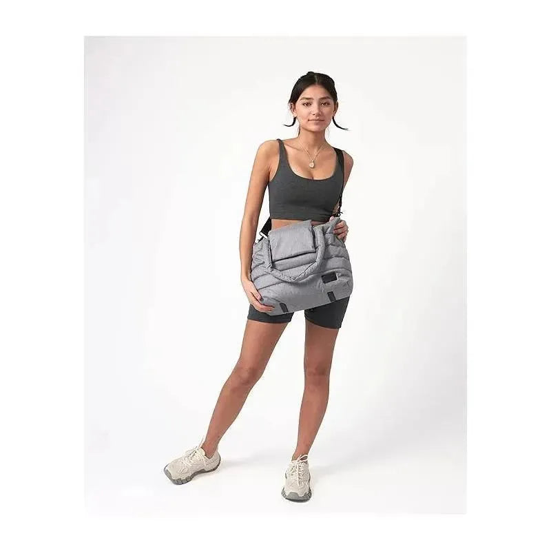 Heather grey Capri diaper bag tote worn by a woman in a sporty outfit, showcasing its spacious design and style.