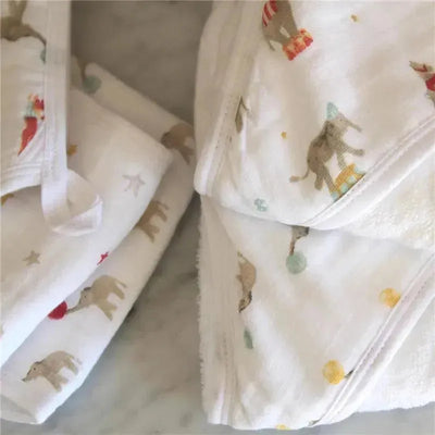 Hooded baby bath towels featuring an elephant circus design in soft colors and playful patterns, ideal for infants.