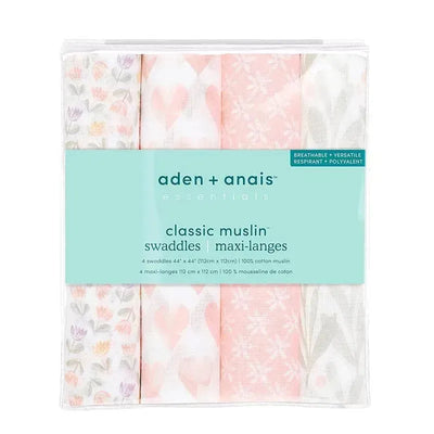 Four Aden + Anais muslin swaddles in floral and heart patterns, highlighting breathable, versatile design.