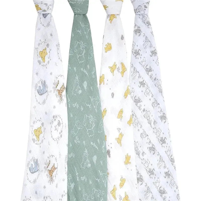 Four muslin swaddles featuring whimsical Winnie the Pooh and friends illustrations in soft pastel colors.
