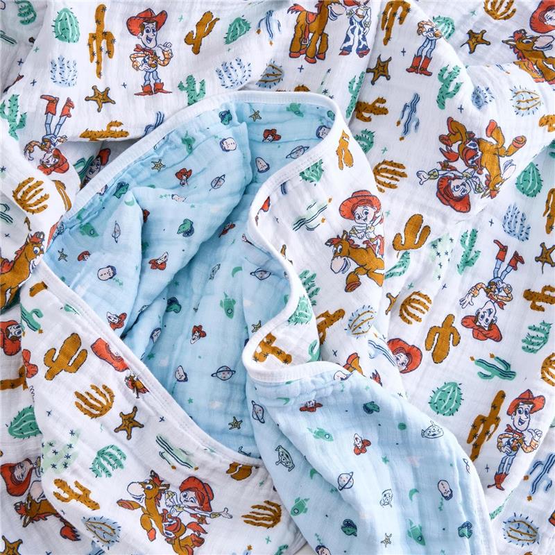 Cotton muslin blanket featuring Toy Story characters Woody and friends, with colorful illustrations on a white and blue background.