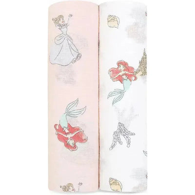 Muslin swaddles featuring Disney Princess designs: one with Cinderella on a pink background and the other with Ariel on white.
