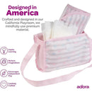 Baby doll diaper bag in pastel pink with changing mat and doll diapers, designed to inspire imaginative play.