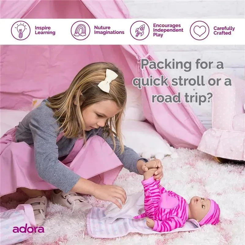 A young girl dressed in gray and pink gently prepares a baby doll for play, surrounded by a pastel pink setting.