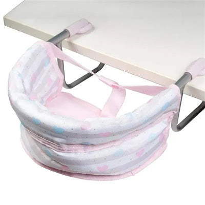 Pastel pink feeding seat designed for dolls, featuring a padded seat with heart patterns and adjustable straps for attachment.