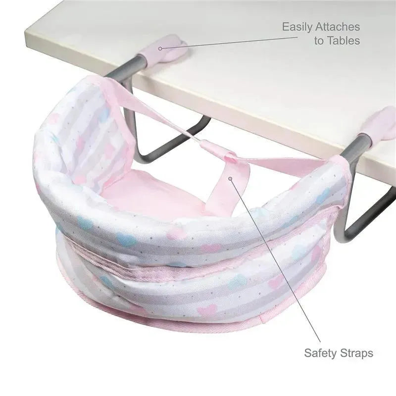 Pastel pink feeding seat for dolls attaches easily to tables, featuring safety straps and a cushioned design.