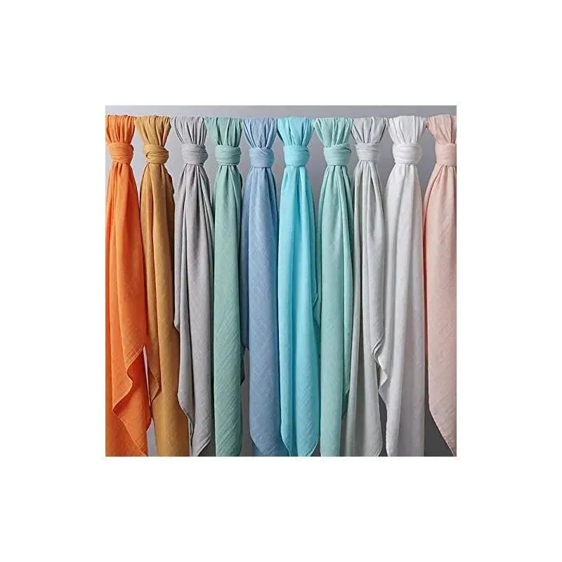 Ali + Oli Muslin Swaddle Blankets in various colors hanging, showcasing Dream Blue among them, emphasizing softness and versatility.