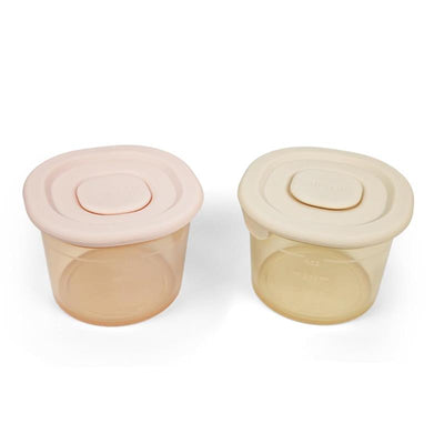 Silicone food containers in blush and khaki colors, 4 oz each, with flat, secure lids.