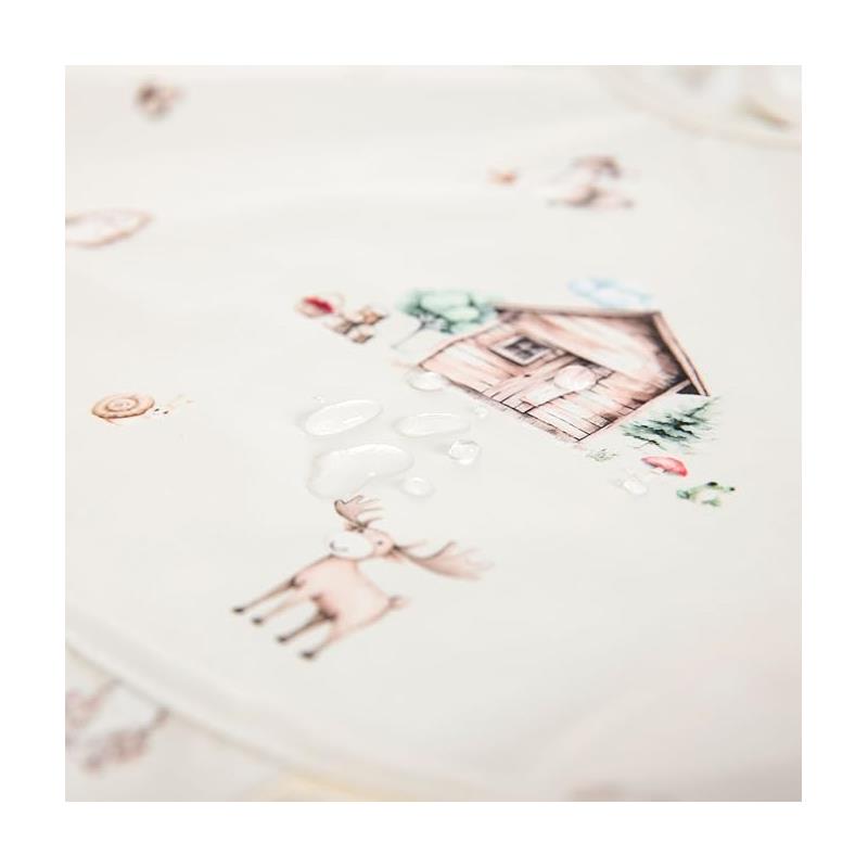 Smock bib featuring woodland illustrations, including a moose, snail, and a wooden cabin, with visible water droplets.