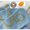 Amber Stone Baroque Baltic Amber Bracelet and necklace displayed on a light blue sweater, showcasing warm amber hues and unique shapes.