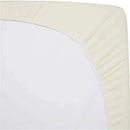 Cream-colored fitted bassinet sheet made of 100% natural cotton jersey knit, neatly wrapped around a mattress corner.