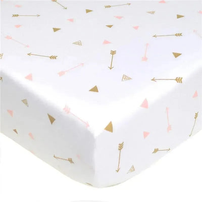 Fitted crib sheet with a white background featuring gold arrows and pink triangles, made of 100% cotton jersey knit.