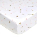 Fitted crib sheet with a white background featuring gold arrows and pink triangles, made of 100% cotton jersey knit.