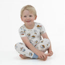 Child wearing a short sleeve loungewear set featuring playful cowdog illustrations, smiling while seated.