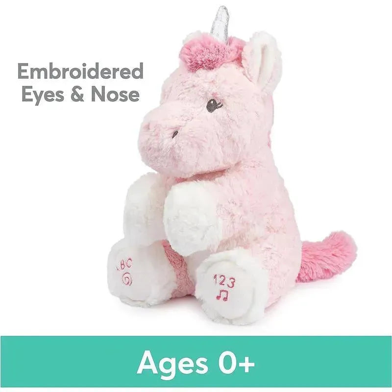 Pink plush unicorn toy with embroidered eyes and nose, featuring design elements like ABC and 123 on its feet, suitable for ages 0+.